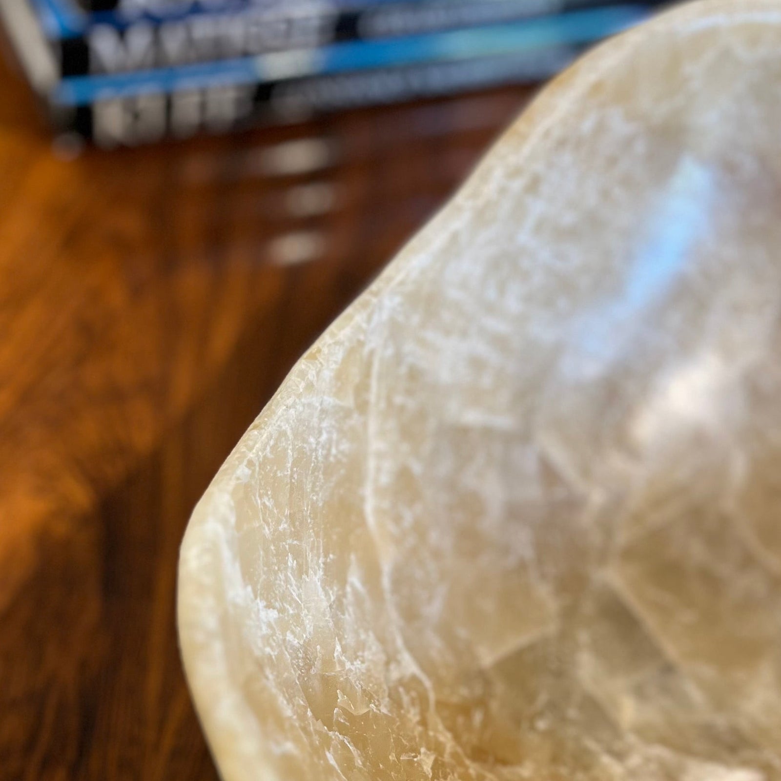 Polished onyx bowl with natural fissures on a wooden surface